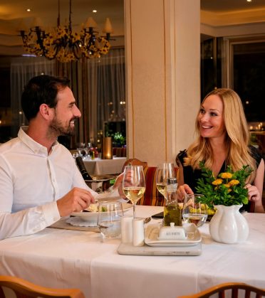 Paar beim Abendessen an einem festlich gedeckten Tisch im Restaurant