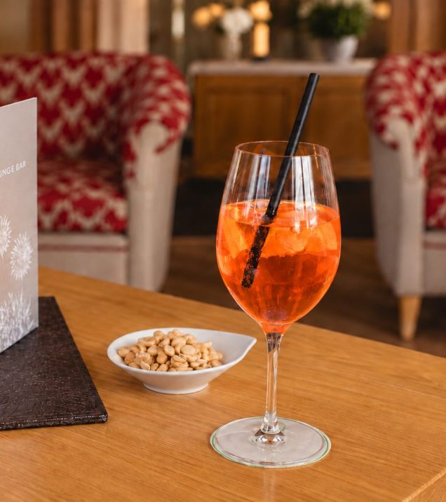 Aperitif in a glass with nuts on a table in the lounge.