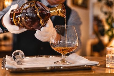 An der Bar wird Cognac in ein Glas eingeschenkt