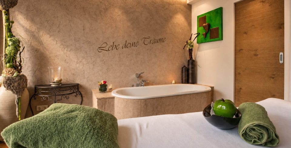 Behandlungsraum mit Badewanne und dem Schriftzug „Lebe deine Träume" im Hotel DreiSonnen in Serfaus