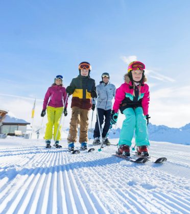 Five skiers on the freshly groomed piste.