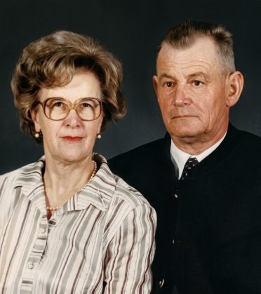 Portrait photo of an older married couple, she with glasses and a striped blouse, he in a dark Janker jacket.