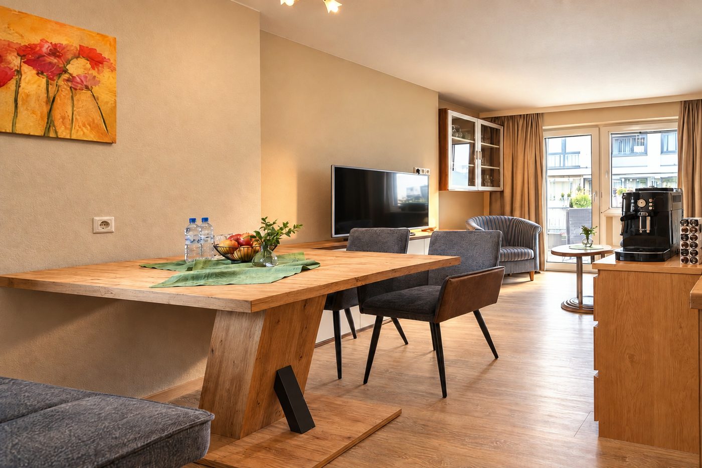 Wooden dining table with chairs, coffee machine and a view to the balcony door in Apartment Anneliese at Hotel DreiSonnen in Serfaus
