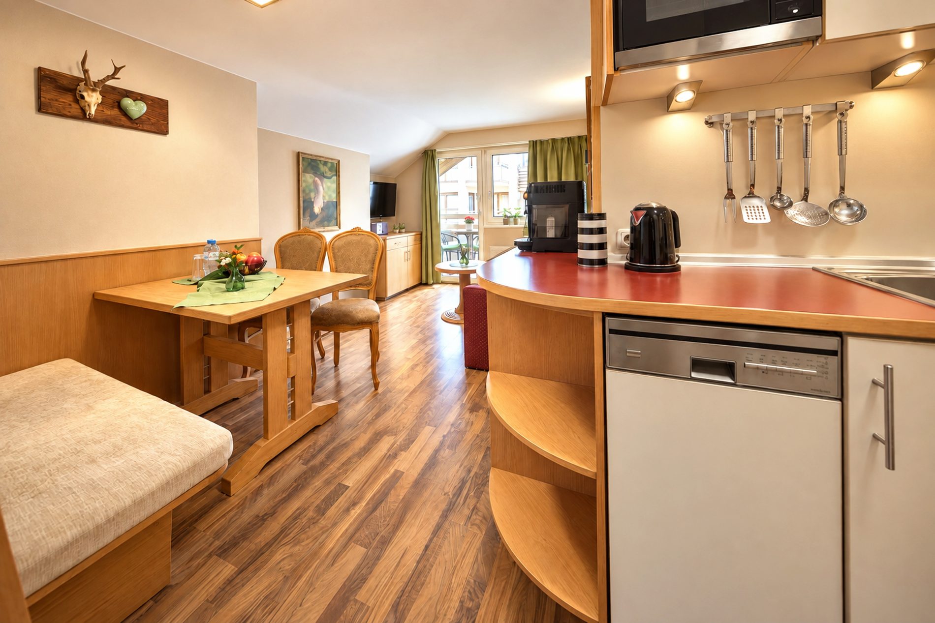 Küchenzeile mit Geschirrspüler und Wasserkocher neben dem Essbereich in der Ferienwohnung Irene des Hotels DreiSonnen in Serfaus