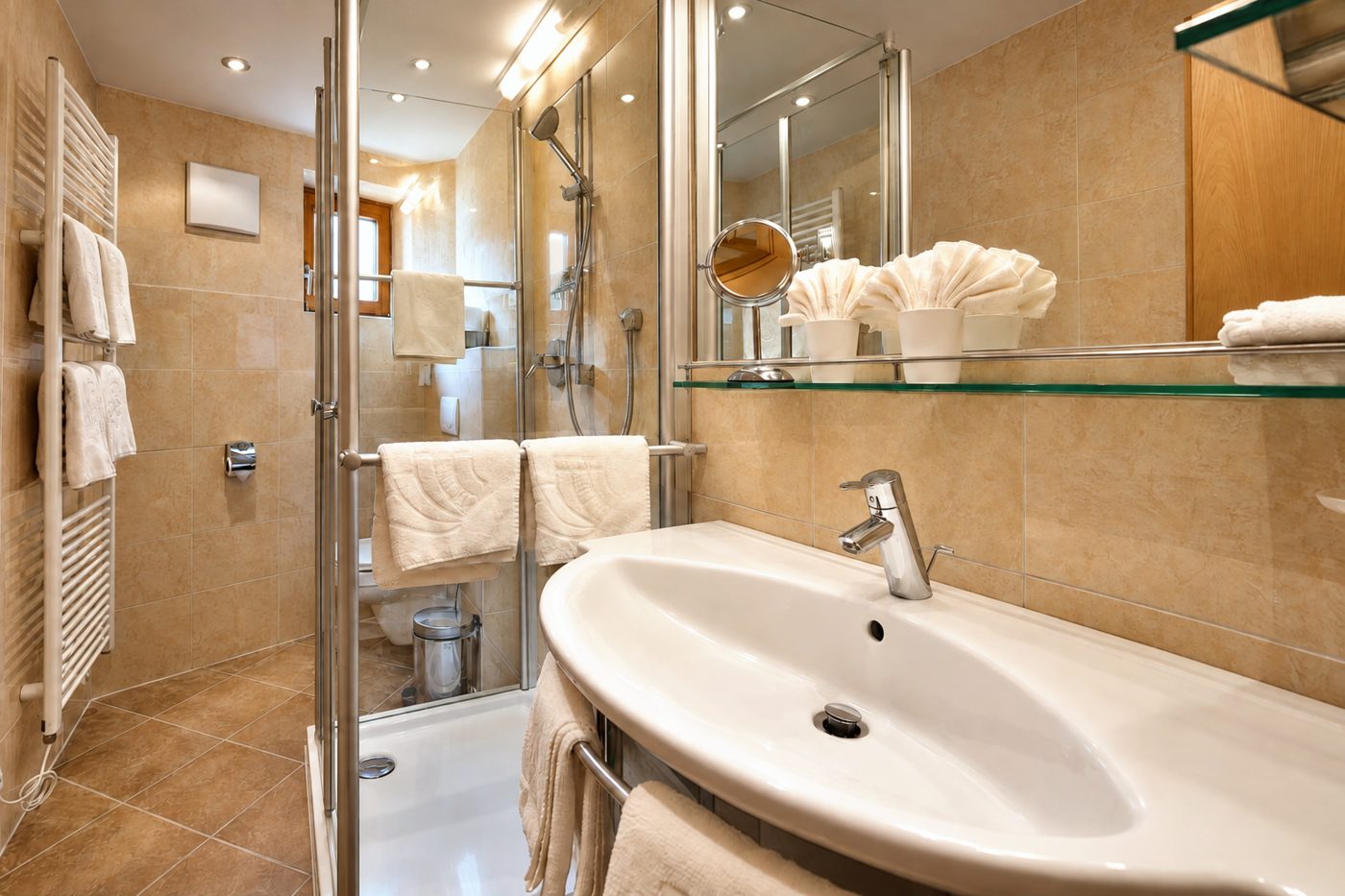 Badezimmer in der Ferienwohnung Irene des Hotels DreiSonnen in Serfaus mit Waschtisch, Spiegel und Dusche