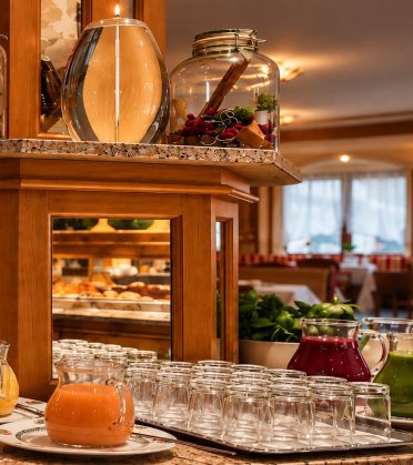 Drinks island with jugs full of juice and glasses set out in the breakfast room of Hotel DreiSonnen.