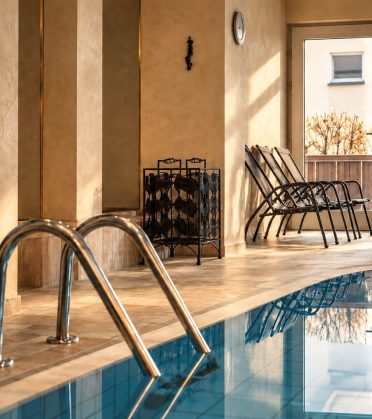 View across the indoor pool to the pool steps with handrail
