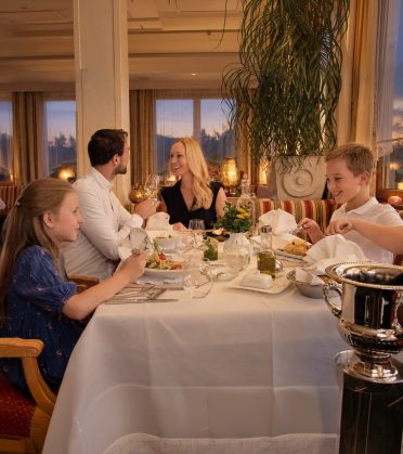 Family with three children at dinner at the laid table at Hotel DreiSonnen in Serfaus