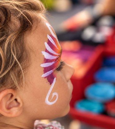 A child with a butterfly painted on their face at face painting in Hotel DreiSonnen in Serfaus