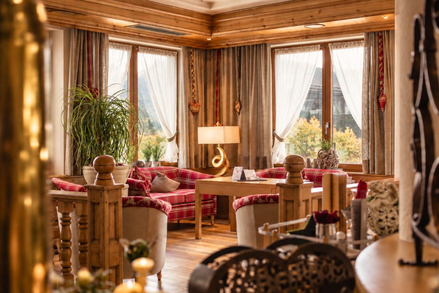 Loungeecke mit karierten Polstermöbeln vor den Fenstern im Hotel DreiSonnen.