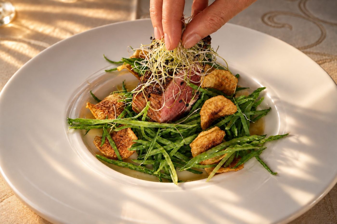 Rindersalat mit Rucola und Chips wird auf dem Teller angerichtet.