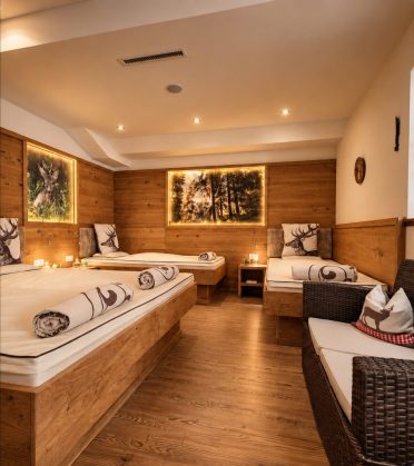 Quiet room with loungers and forest pictures on the wooden wall at Hotel DreiSonnen in Serfaus