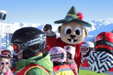 Group of children in a ski course with the mascot Murmli on the practice slope in Serfaus.