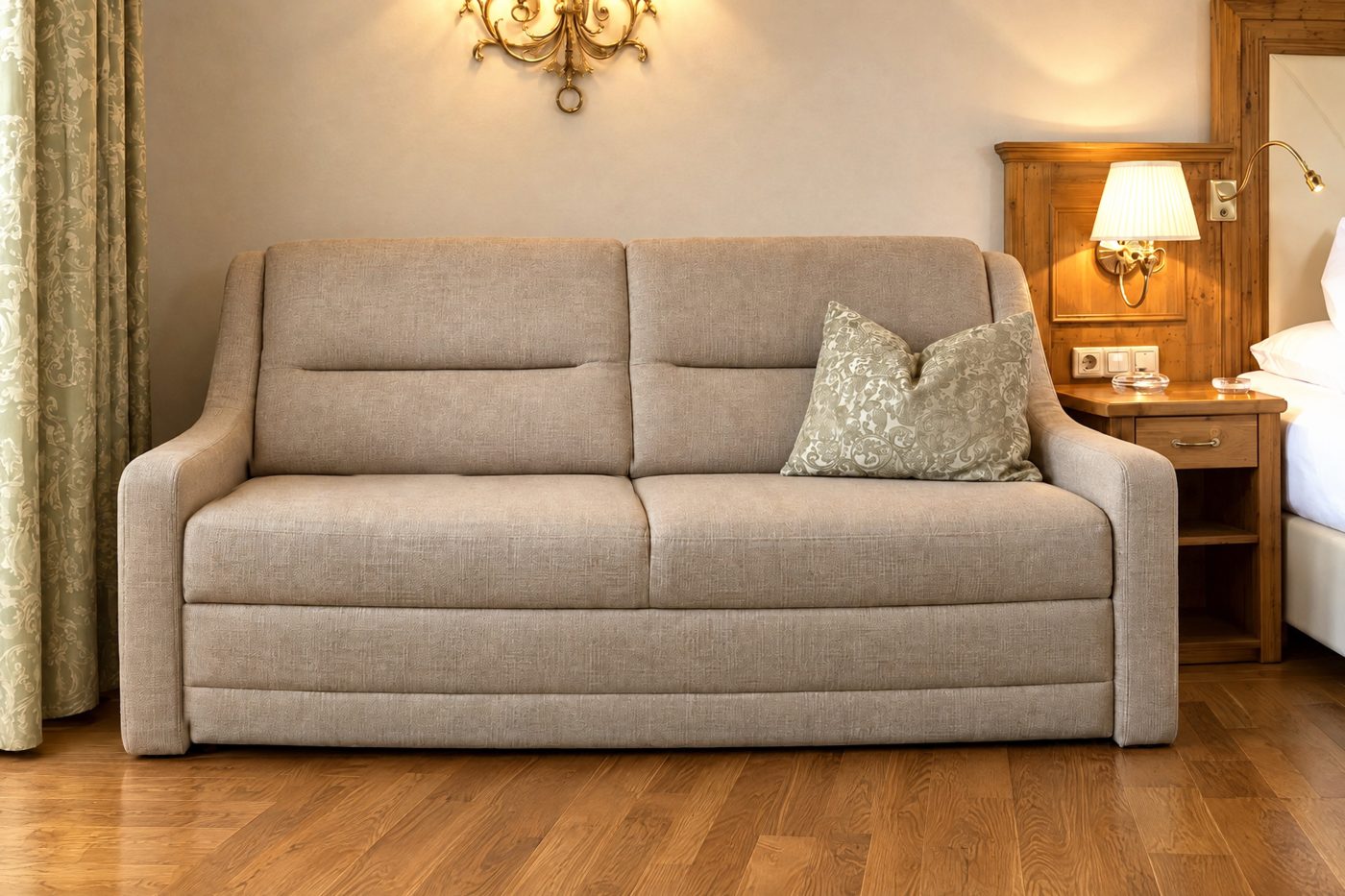 Sofa mit Zierkissen unter der Wandleuchte neben dem Bett in einer vergleichbaren Deluxe-Suite vom Typ des Zimmers Elias im Hotel DreiSonnen in Serfaus