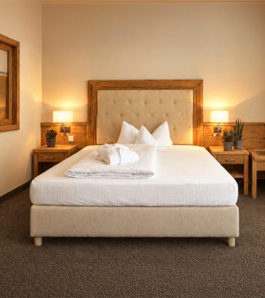 Florian room at Hotel DreiSonnen in Serfaus with bed, desk, TV and oak furniture