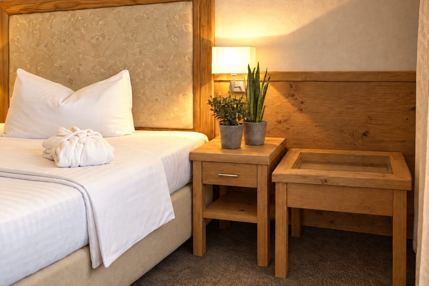 Oak bedside table and side table with plants next to the bed in a comparable room of the same type as the room Florian at Hotel DreiSonnen in Serfaus