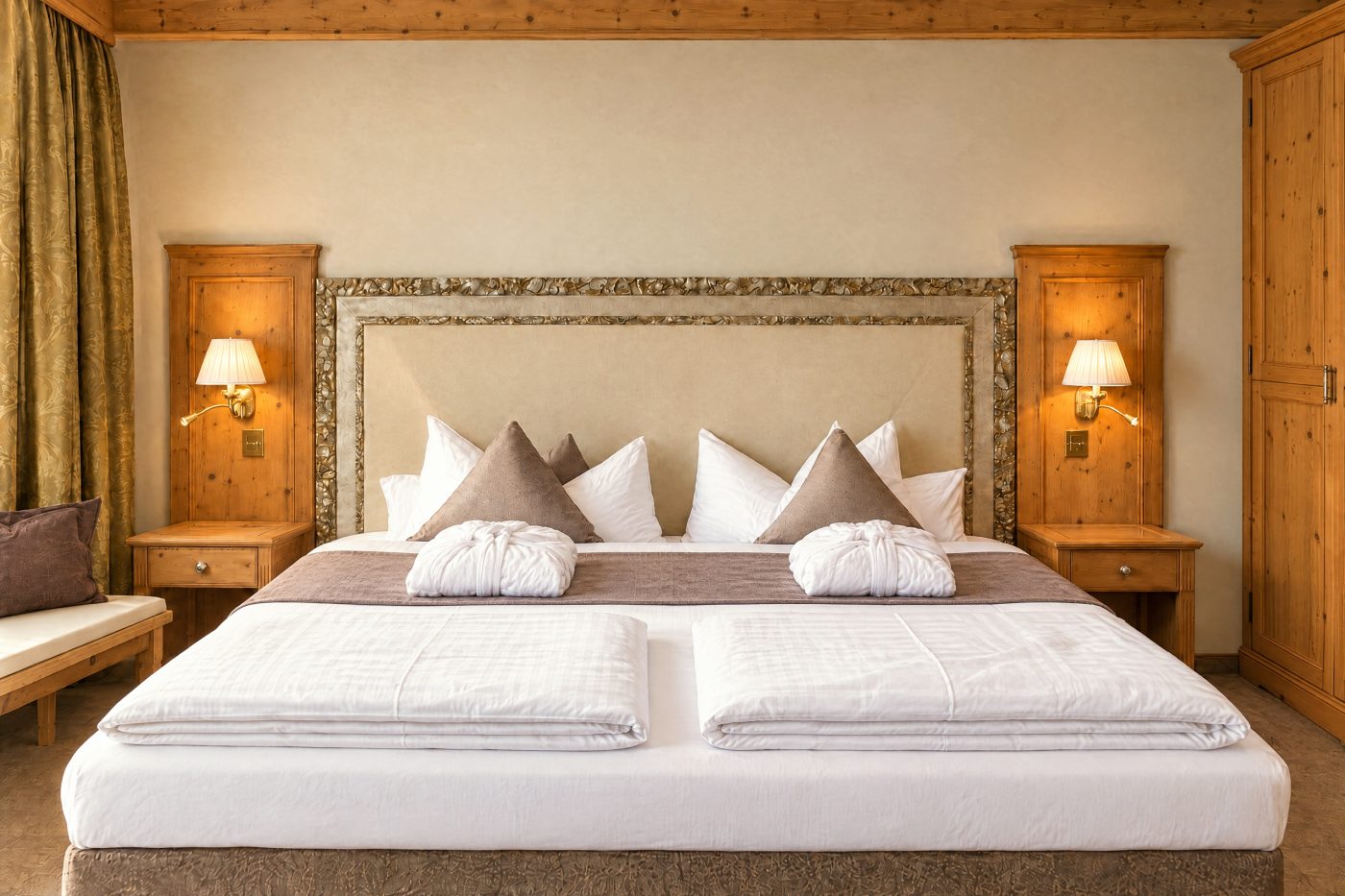 Double bed with upholstered headboard, bathrobes and bedside lamps in the Kaiser Franzl room at Hotel DreiSonnen in Serfaus
