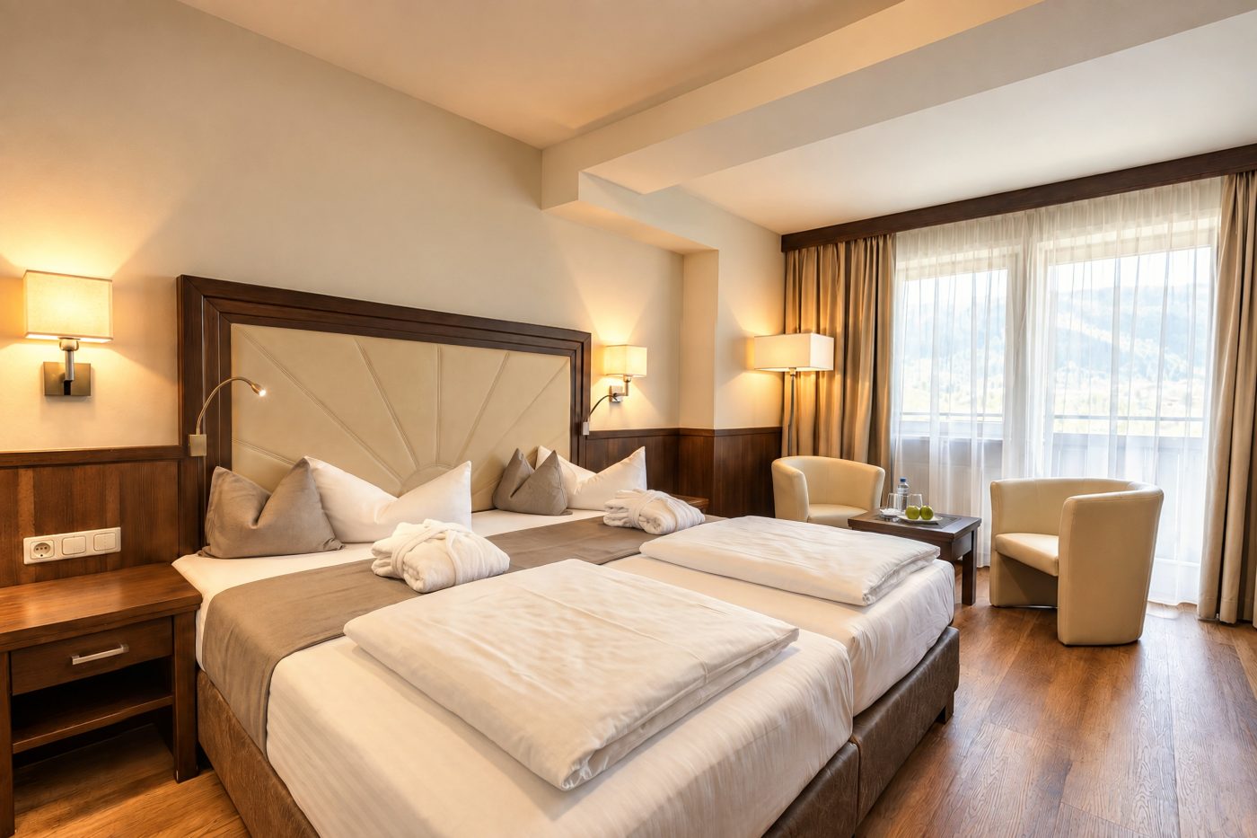 Vergleichbares Komfort-Doppelzimmer vom Typ des Zimmers Jonas im Hotel DreiSonnen in Serfaus mit Doppelbett, zwei Sesseln und Fensterfront mit Bergblick