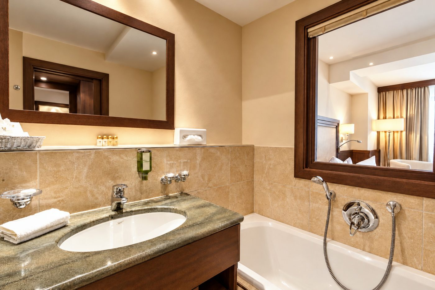 Badezimmer mit Waschtisch, Spiegel und Badewanne in einem vergleichbaren Komfort-Doppelzimmer vom Typ des Zimmers Jonas im Hotel DreiSonnen in Serfaus