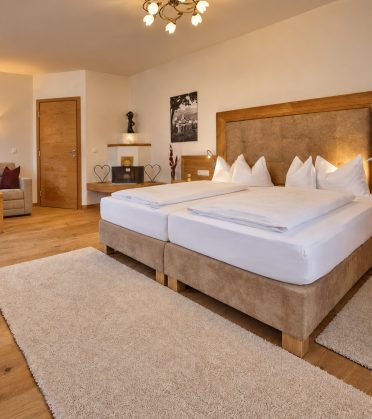 Suite Magdalena im Hotel DreiSonnen in Serfaus mit Doppelbett, Sofaecke und Sprossenfenster
