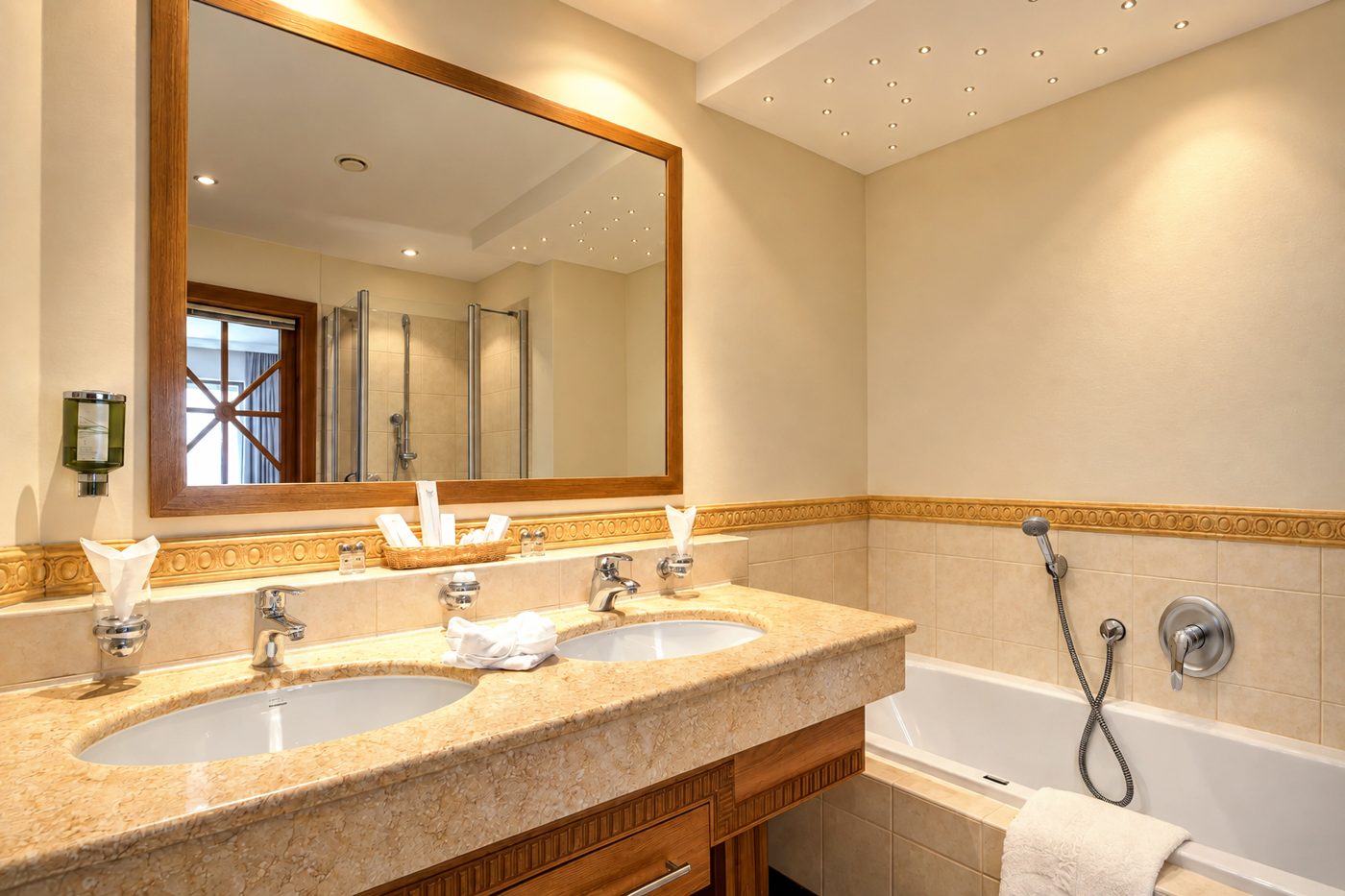 Badezimmer mit Doppelwaschtisch, Spiegel und Badewanne in einer vergleichbaren Suite vom Typ der Suite Magdalena im Hotel DreiSonnen in Serfaus