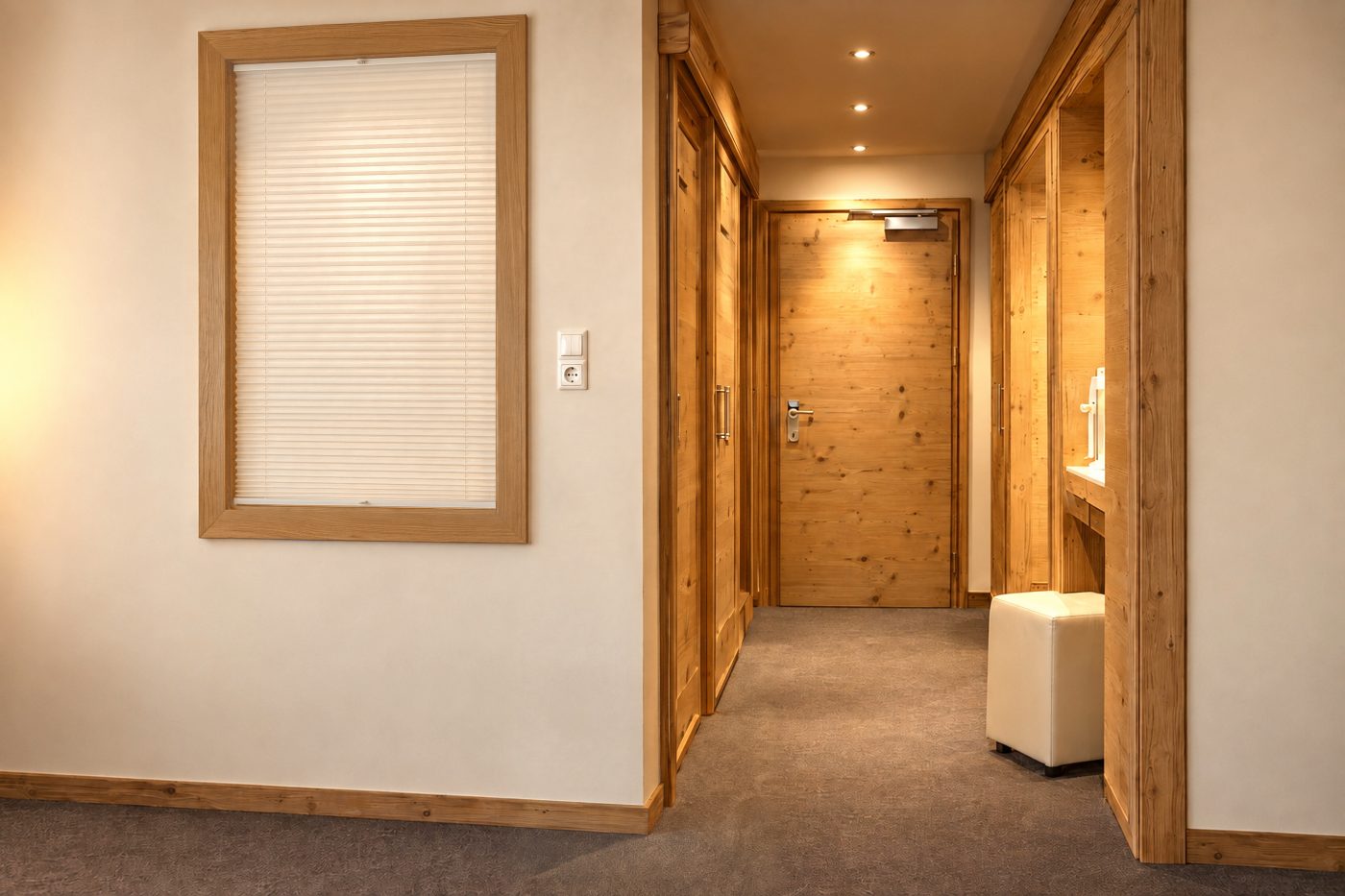 Eingangsbereich im Zimmer Marlene des Hotels DreiSonnen in Serfaus mit Wandspiegel, Pflanze, Holztür und Garderobe