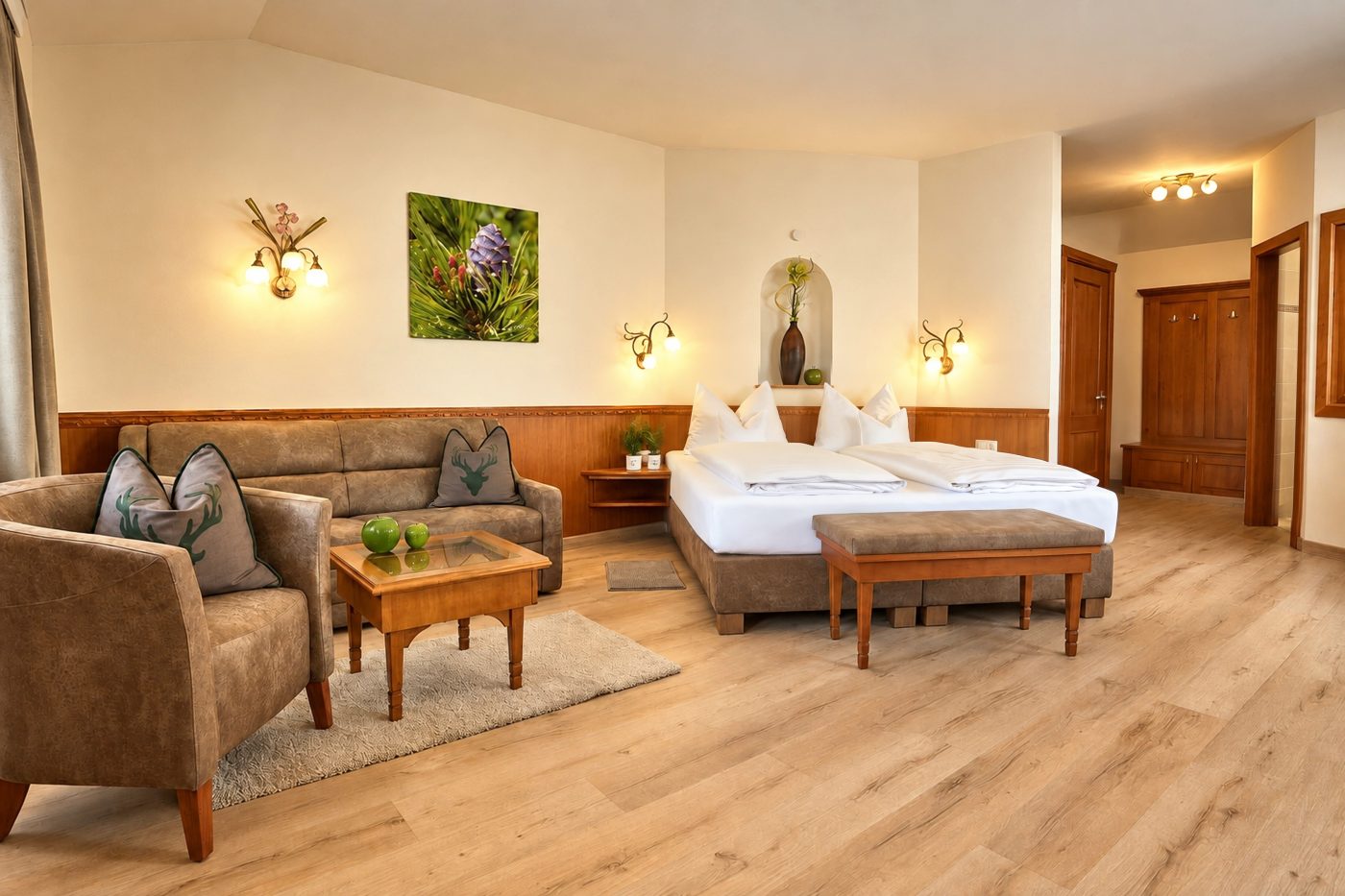Doppelbett mit Wandnische und Sitzgruppe aus Sofa und Sessel im Komfort-Familienzimmer Mona Lisa des Hotels DreiSonnen in Serfaus