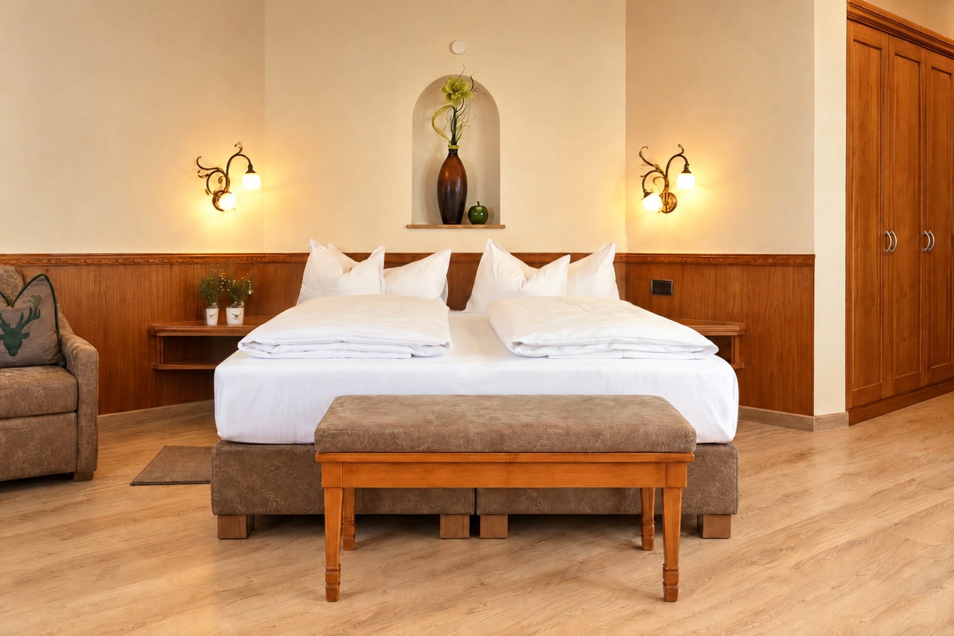 Doppelbett mit Wandnische, Bank und Blumenstrauß im Zimmer Mona Lisa des Hotels DreiSonnen in Serfaus