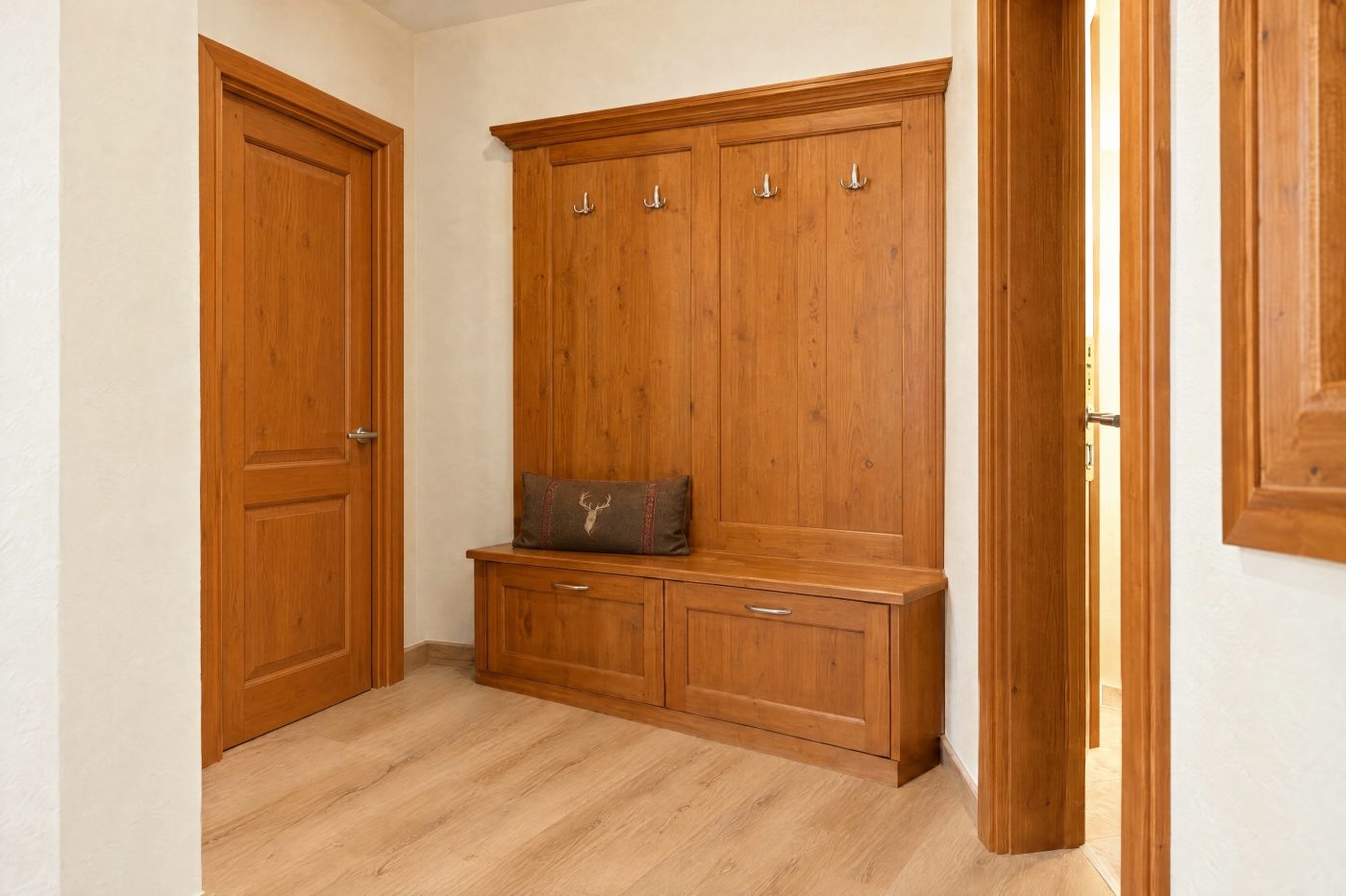 Garderobe mit Sitzbank und Kleiderschrank aus Holz im Eingangsbereich des Zimmers Mona Lisa im Hotel DreiSonnen in Serfaus
