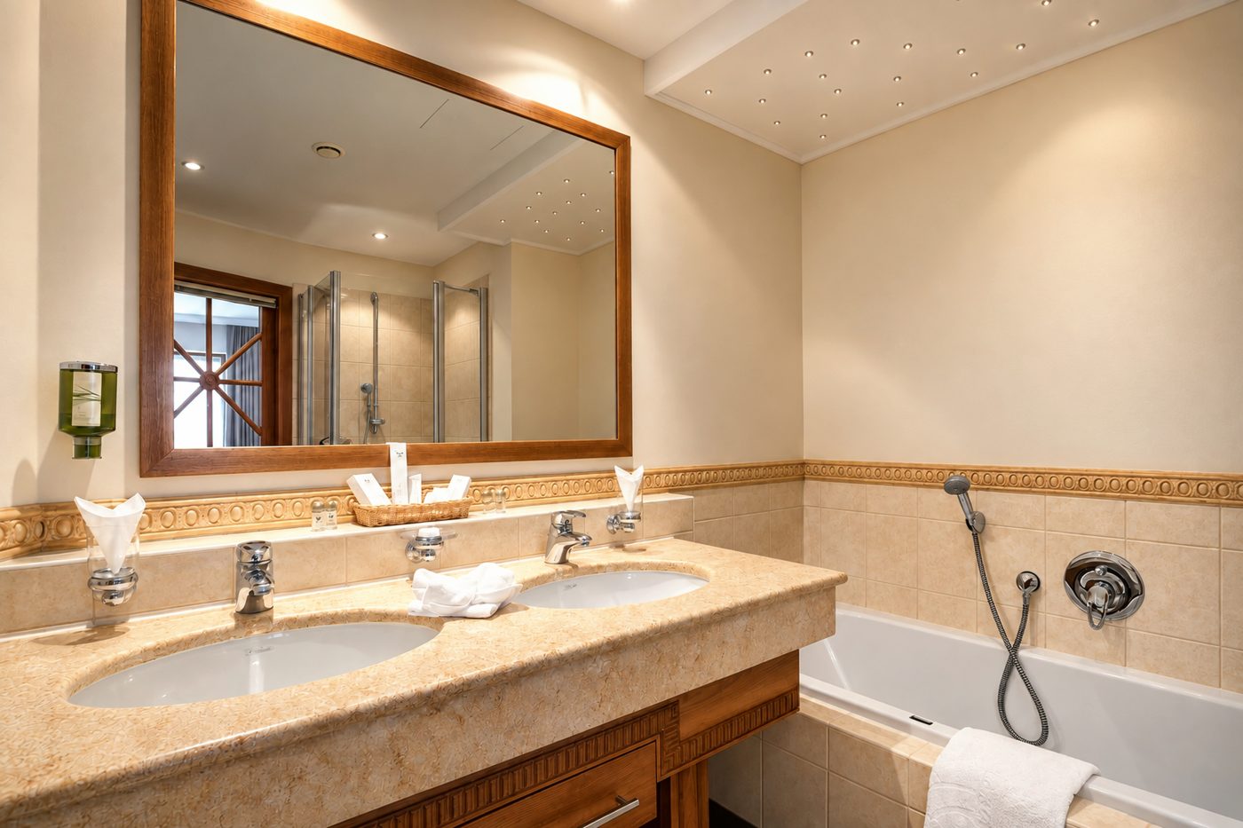 Badezimmer im Zimmer Mona Lisa des Hotels DreiSonnen in Serfaus mit Doppelwaschtisch, Spiegel und Badewanne