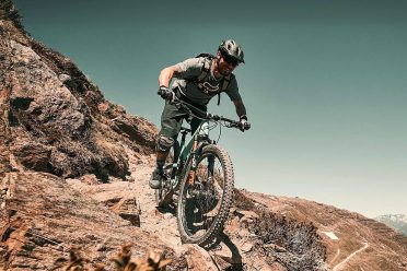 Ein Mountainbiker fährt über felsiges Gelände bergab.