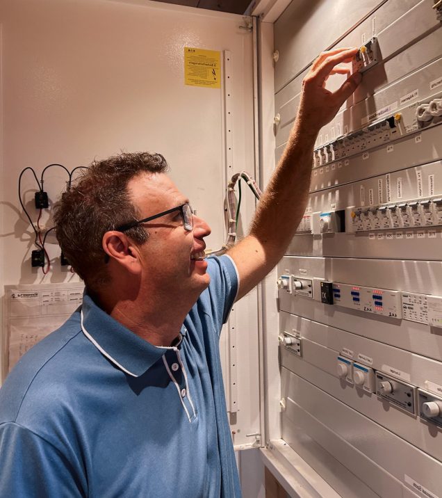 Martin Lechleitner checking a control cabinet in the plant room of Hotel DreiSonnen.