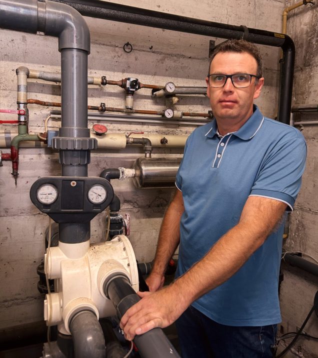 Martin Lechleitner in the plant room of Hotel DreiSonnen at an installation with pipes and pressure gauges.