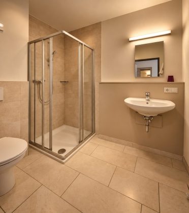 Private bathroom in the staff house of Hotel DreiSonnen with shower, WC and washbasin.