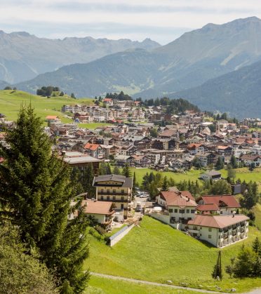 Blick über den Ort mit Hotels und Häusern, dahinter die Bergkette.