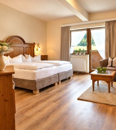 Vergleichbares Zimmer vom Typ der Suite Elisabeth im Hotel DreiSonnen in Serfaus mit Doppelbett, Sessel und Couchtisch